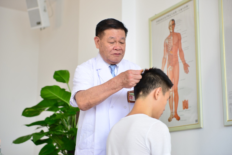 国医大师黄瑾明为患者进行壮医药线点灸疗法治疗。威斯尼斯人娱乐平台供图